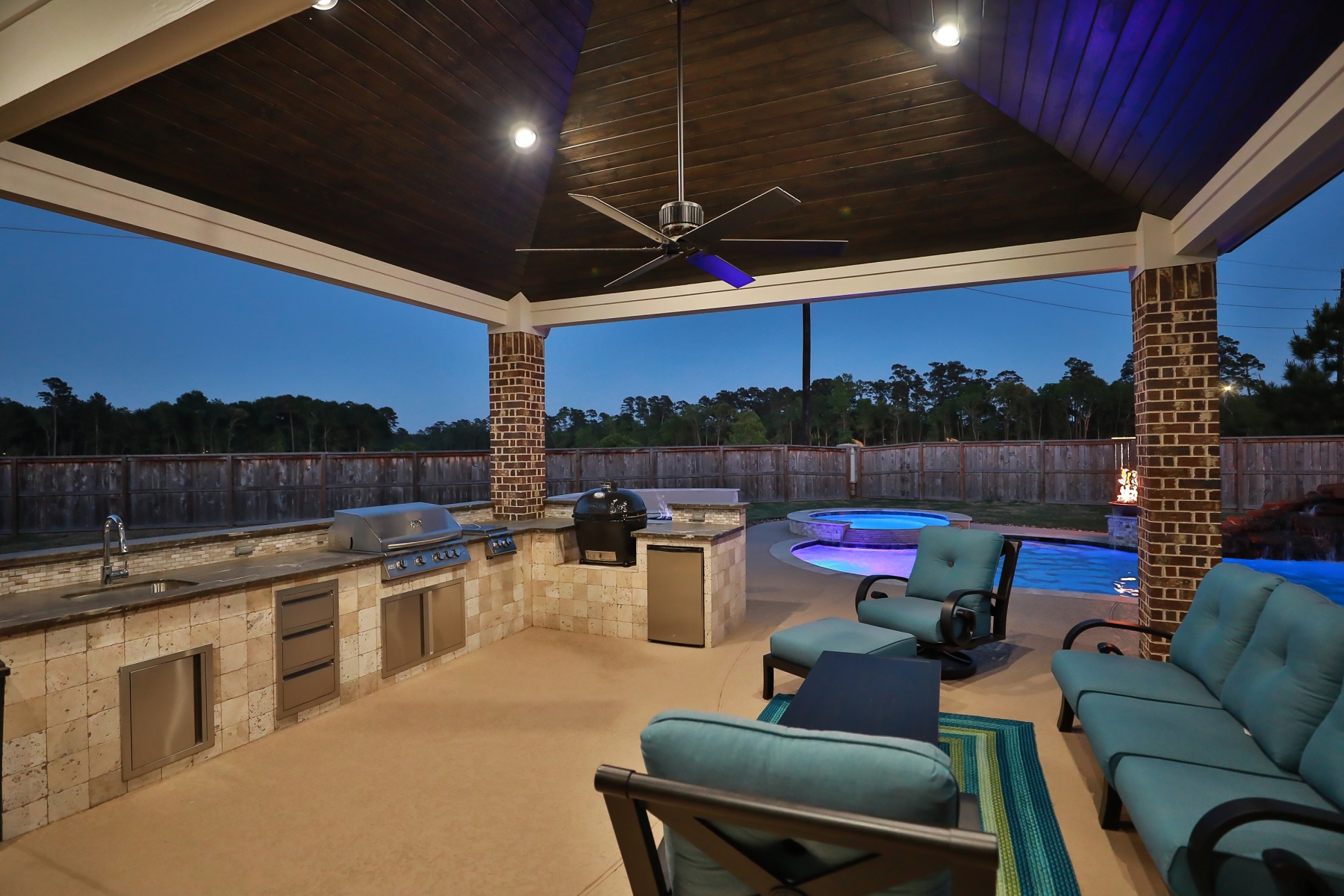 Covered Patio with Outdoor Kitchen & Living Area Overlooking Pool
